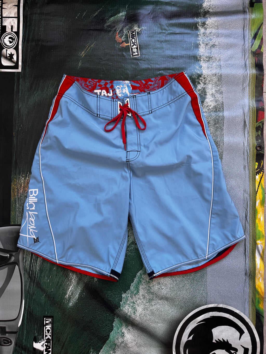 Vintage Y2K Billabong Taj Burrow signature boardshorts in blue and red, front view