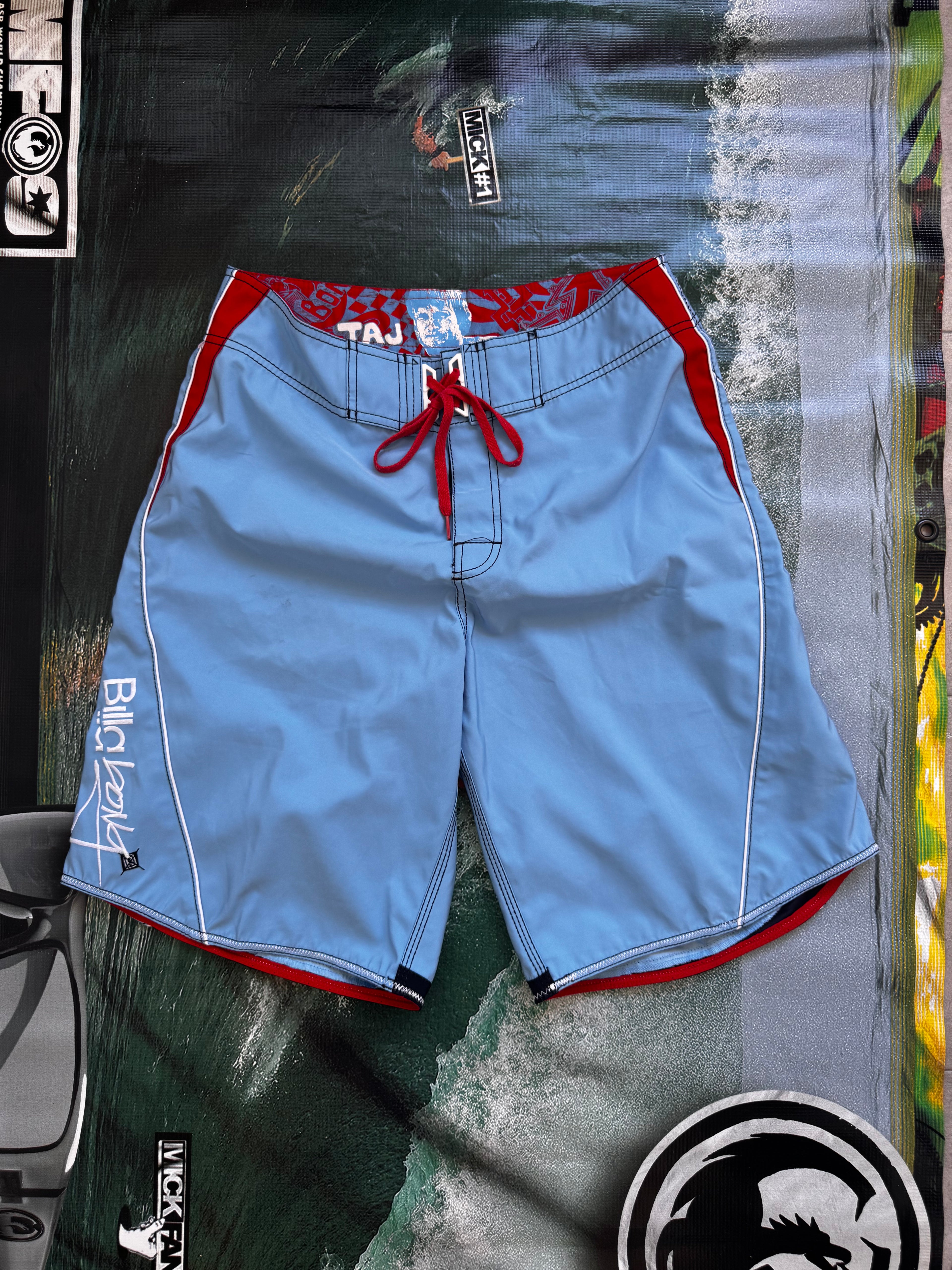 Vintage Y2K Billabong Taj Burrow signature boardshorts in blue and red, front view