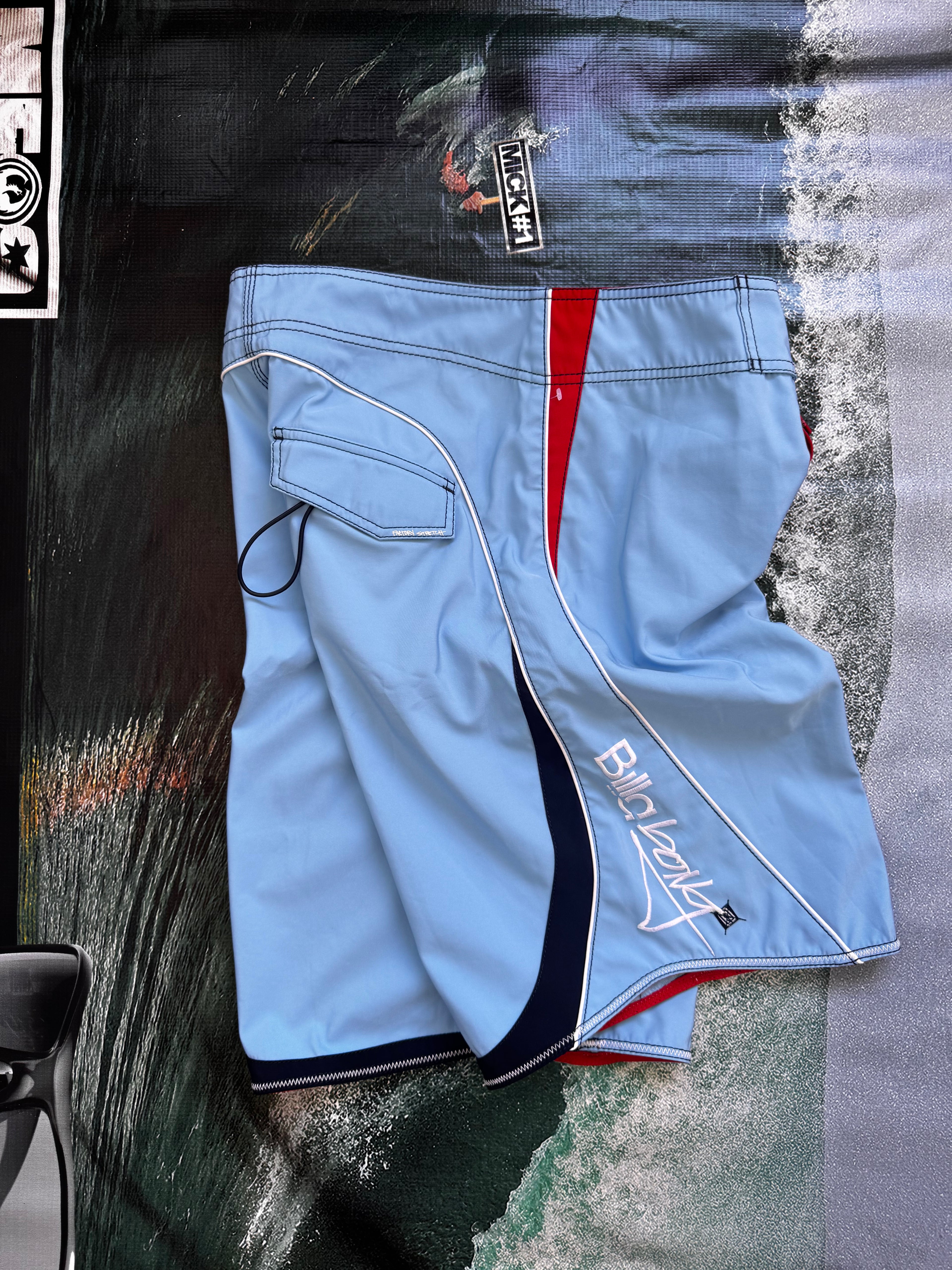 Vintage Y2K Billabong Taj Burrow signature boardshorts in blue and red, back view