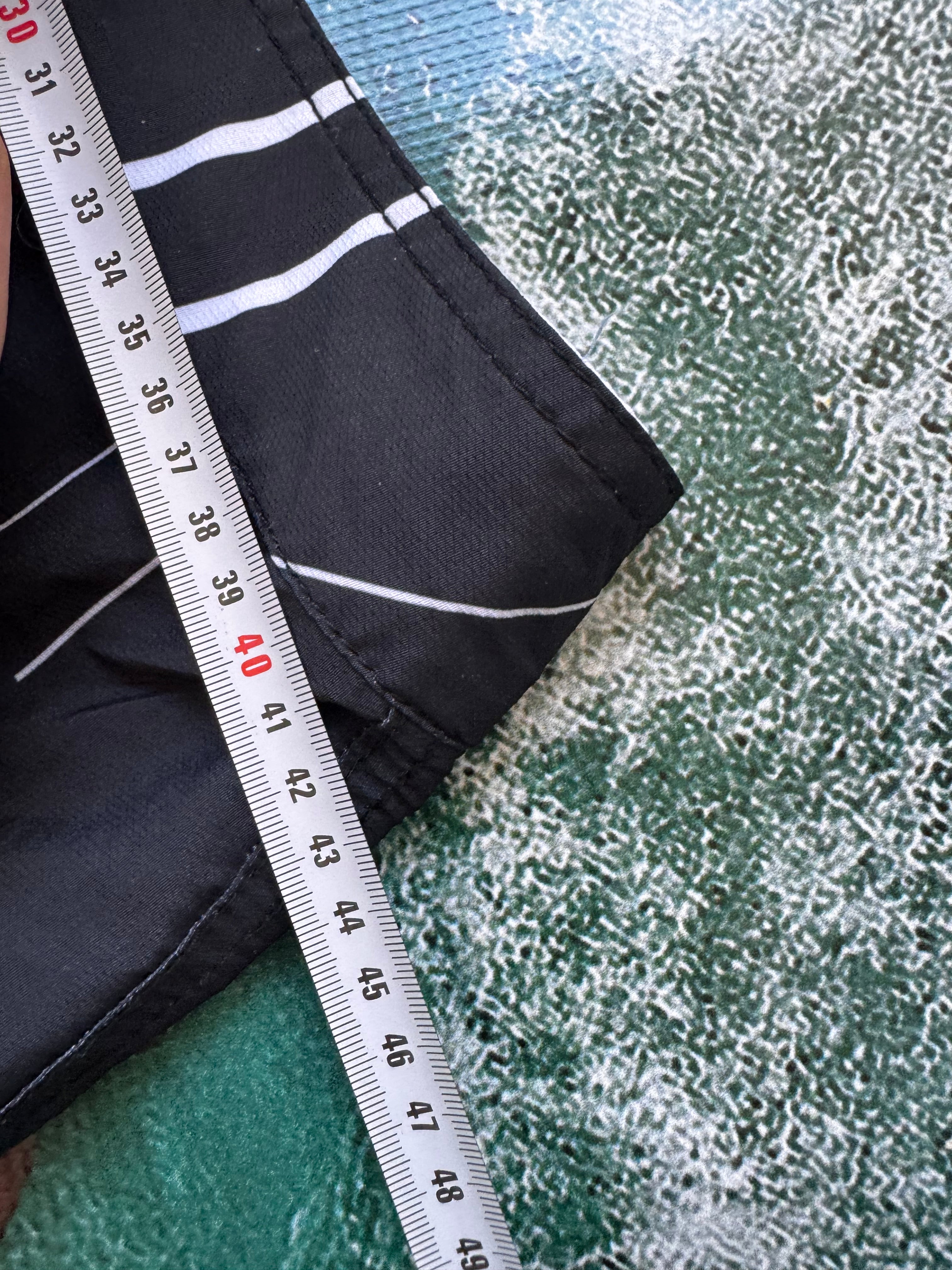 Vintage Y2K Rip Curl boardshorts in navy and white, flat lay